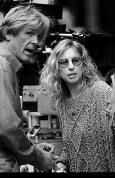 a man and woman standing next to each other in front of a movie camera set