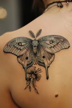 a woman with a butterfly tattoo on her back