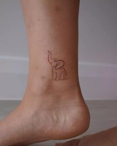 a small elephant tattoo on the side of a woman's foot, which is drawn in black ink