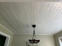 a room with white painted walls and wood flooring, including a ceiling fan that is hanging from the ceiling