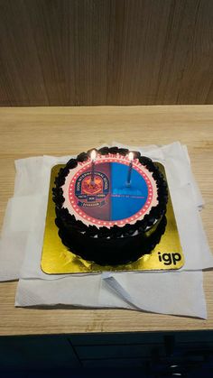 a birthday cake sitting on top of a white napkin next to a knife and fork