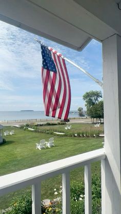 an american flag blowing in the wind on a porch