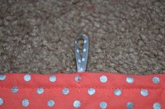 a piece of fabric with silver polka dots is laying on the floor next to a pair of scissors