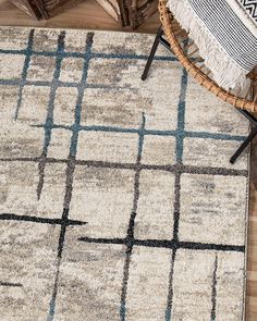 an area rug on the floor with a chair next to it and a wicker basket