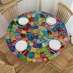 a colorful table with plates and cups on it in the shape of a mosaic tile