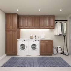 a washer and dryer in a room with wooden cabinets on either side of the washer