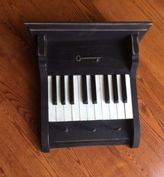 an old black piano sitting on top of a wooden floor