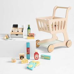 a toy shopping cart sitting on top of a table next to other toys and items