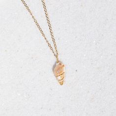 Description: This dainty seashell necklace features a tiny conch shell delicately wrapped in golden wire. Length: 18 inches Materials: Handcrafted using a genuine shell, non-tarnish golden lacquered copper wire, and stainless steel chain. Dainty Shell Charm Necklace For Beach, Dainty Shell Necklaces Perfect As Gifts, Wire Wrapped Shell Necklaces In Shell Shape, Wire Wrapped Shell Necklaces, Gold Wire-wrapped Necklaces For The Beach, Gold Wire Wrapped Necklace For The Beach, Dainty Gold Shell Charm Necklace, Gold Wire Wrapped Shell Necklace, Wire Wrapped Shell Necklace Gift