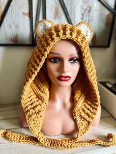 a mannequin wearing a yellow knitted hat with ears and tail on it's head