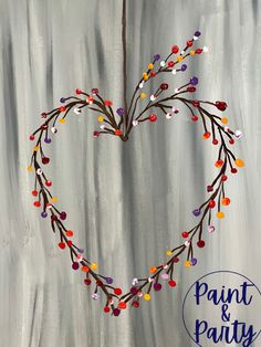 a painting of a heart made out of branches with colorful beads hanging from it's center