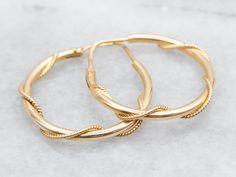 Gold hoops are an essential item in any jewelry collection! These beauties are crafted from 18-karat gold and have a twisted design that catches the light beautifully. Big enough to make a statement, these hoop earrings are also lightweight and perfect for everyday wear. Metal: 18K Yellow Gold Measurements: 4 x 28 mm Marks: "750 *787" Stamped on the findings SKU #: A39705 Each piece has been identified and graded by a Graduate Gemologist who has been certified by the Gemological Institute of America (GIA). We have six brick-and-mortar storefronts in Maine, Massachusetts, and New Hampshire and have been in business for over 25 years! Please visit our Shop's About Page or our website for more information about our jewelry. For questions about diamond grading, we recommend the Gemological Ins Twisted Gold Plated Yellow Gold Hoop Earrings, Gold Plated Hoop Earrings With A Modern Twist, Twisted Yellow Gold Hoop Earrings, Tarnish Resistant, Twisted 14k Yellow Gold Hoop Earrings, Yellow Gold Hoop Earrings With A Modern Twist, Modern Twist Yellow Gold Hoop Earrings, Modern Twist Small Hoop Earrings In Yellow Gold, Yellow Gold Round Earrings With A Modern Twist, Modern Twist Yellow Gold Small Hoop Earrings