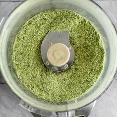 an overhead view of a food processor with green stuff in it's bottom bowl