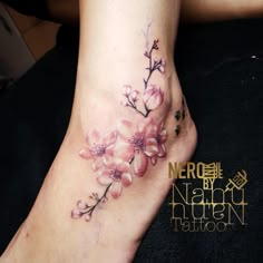 a close up of a person's foot with flowers on it and the words nerd by namun tattoo