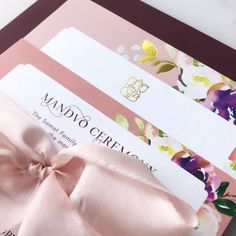 a close up of a pink bow on a card with some other cards in the background