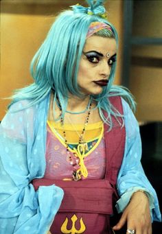 a woman with blue hair and makeup is dressed as a character from the tv show