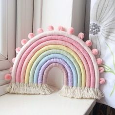 a rainbow shaped pillow sitting on top of a window sill