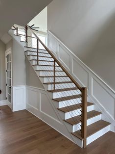 a stair case in a house with wood floors and white railings on the side