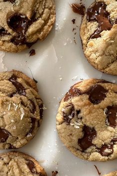 chocolate chip cookies with coconut flakes and sea salt on top in a white box