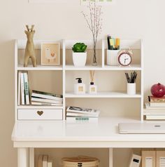 a white desk topped with lots of books next to a shelf filled with office supplies