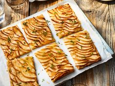 sliced apple slices are arranged on a baking sheet, ready to be baked in the oven