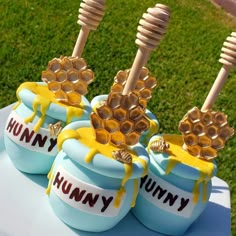 three blue jars with honeycombs and bees on them