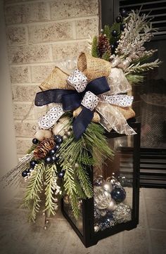 a christmas wreath with pine cones and blue berries