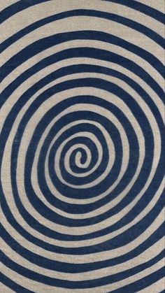 a blue and white rug with an abstract design in the middle, on top of it