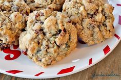 three cookies are on a plate with red and white paper around it, sitting on a wooden table