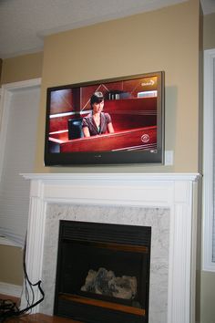 a flat screen tv mounted above a fireplace