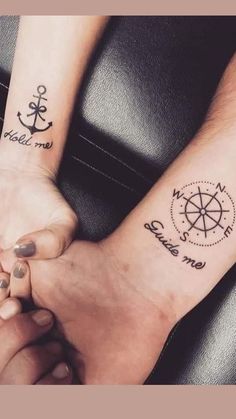 two people holding hands with tattoos on their arms and one has a compass tattoo on the wrist