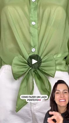 a woman standing in front of a green shirt with a large bow on it's back