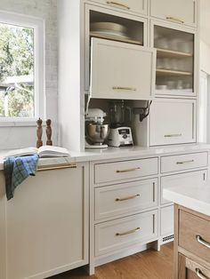 a kitchen with white cabinets and gold pulls on the handles, drawers and cupboards