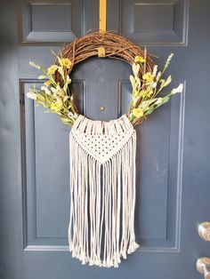 a door with a wreath and flowers hanging from it's side, next to a blue door