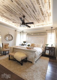 a large white bed sitting under a wooden ceiling