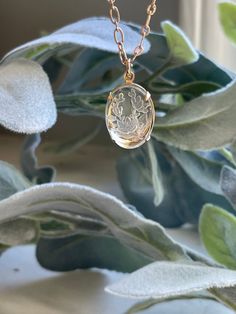 "A clear Intaglio stone with a boho floral swag etched in the reverse. The stone is set with an open back 4 prong setting to get the full effect of its beauty. Intagli are an ancient style of carved or pressed glass in Ancient Greece, Rome and the Middle East. They are also referred to as Venetian glass. 18\" gold plated chain 18x13 mm pendant Etched glass Minimal design matches everything Exclusive easy to use clasp design" Antique Intaglio Pendant Jewelry, Elegant Medallion Necklace With Intaglio, Elegant Medallion Necklace With Carved Detail, Elegant Medallion Necklaces With Intaglio, Intaglio Pendant Necklace For Wedding, Elegant Carved Pendant Necklace, Elegant Round Pendant Intaglio Necklace, Elegant Carved Round Pendant Necklace, Elegant Etched Oval Jewelry