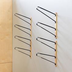 four pairs of scissors are hanging on the wall next to each other with wooden handles