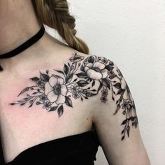 a woman's shoulder with flowers on it, and a heart in the background