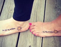 two people with tattoos on their feet standing next to each other and one has the words, you are my sunshine