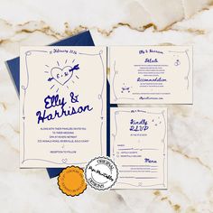 the wedding stationery is laid out on a marble surface