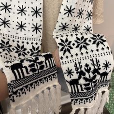 two white and black knitted mittens sitting next to each other