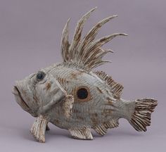 a ceramic fish sculpture on a gray background