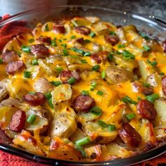 a casserole dish with sausage, potatoes and green onions