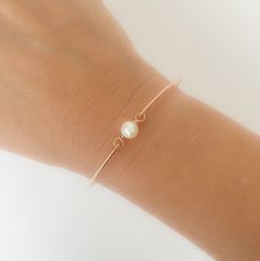 "A small & dainty white cultured freshwater pearl will be transformed into a simple cultured freshwater pearl bangle bracelet with bangle band choice of 14k rose gold filled, 14k gold filled or sterling silver, This cultured freshwater pearl bangle bracelet makes for the perfect minimalist bridesmaid bracelet, simple bridal bracelet, or an everyday simple bracelet. Personalize this simple bangle bracelet with custom initial charms to make personalized bridesmaid bangle bracelets; http://www. Adjustable Pearl Charm Jewelry For Bridesmaid Gift, Adjustable Pearl White Jewelry For Bridesmaid Gift, Simple Rose Gold Jewelry For Bridesmaid Gift, Adjustable Rose Gold Pearl Drop Jewelry, Delicate Rose Gold Pearl Bracelet, Rose Gold Bangle Pearl Bracelet As A Gift, Dainty Rose Gold Pearl Bracelet For Formal Occasions, Minimalist Adjustable Pearl Bracelet For Anniversary, Classic Rose Gold Pearl Bracelet As Gift