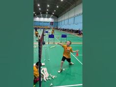 two men are playing badminton on an indoor court