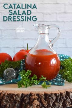 a glass jug filled with tomato sauce sitting on top of a wooden table next to tomatoes and parsley