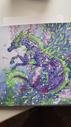 a painting of a purple dragon on a white surface with green and red flowers in the background