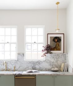 a kitchen with marble counter tops and green cabinets