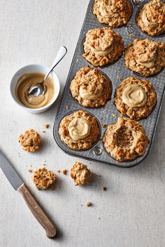 muffins with peanut butter in a muffin tin next to a cup of coffee