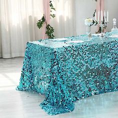 a table covered with blue sequins and candles